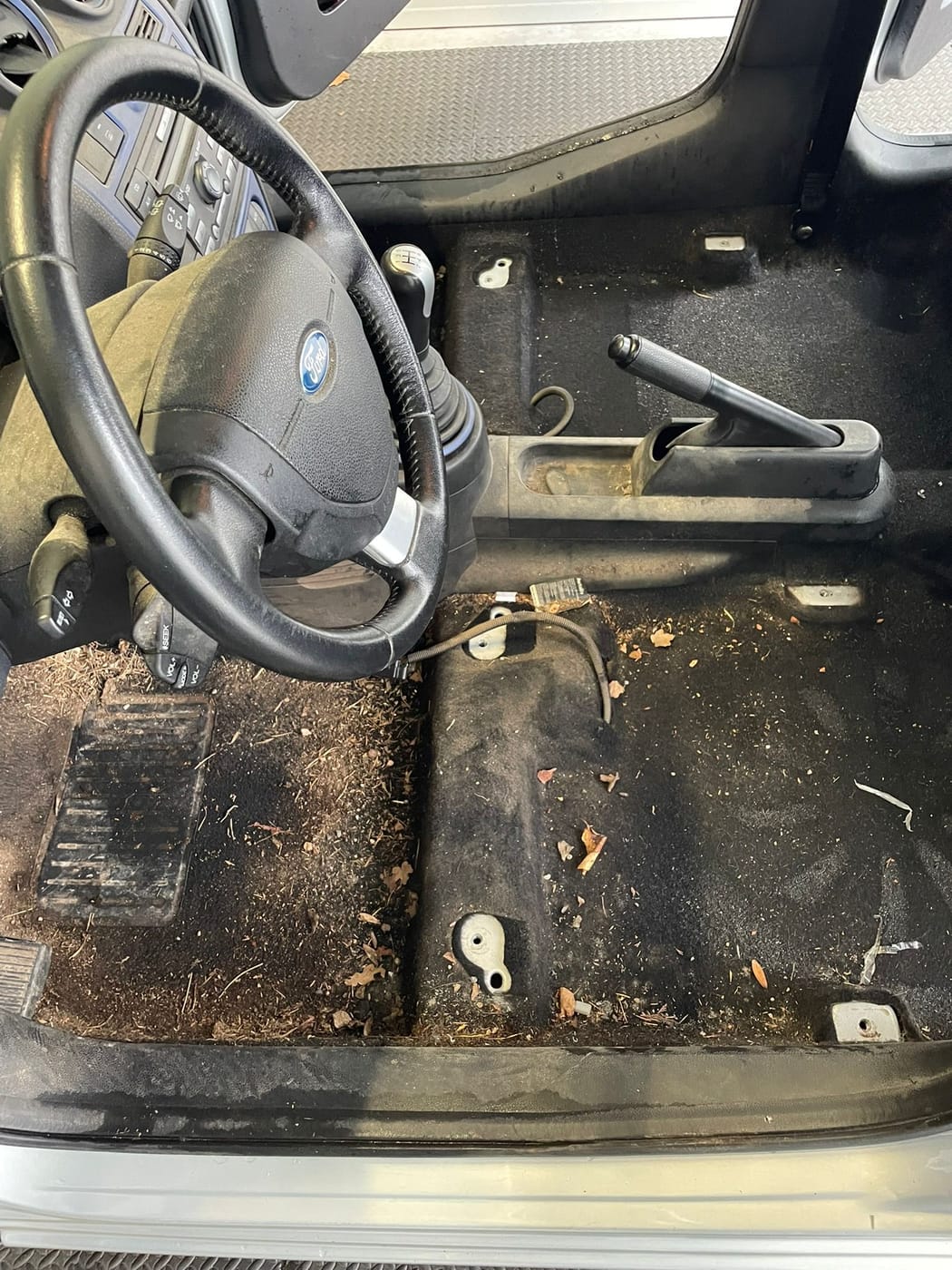 Plancher et tapis conducteur d'une Ford Fiesta, encrassés, avant nettoyage