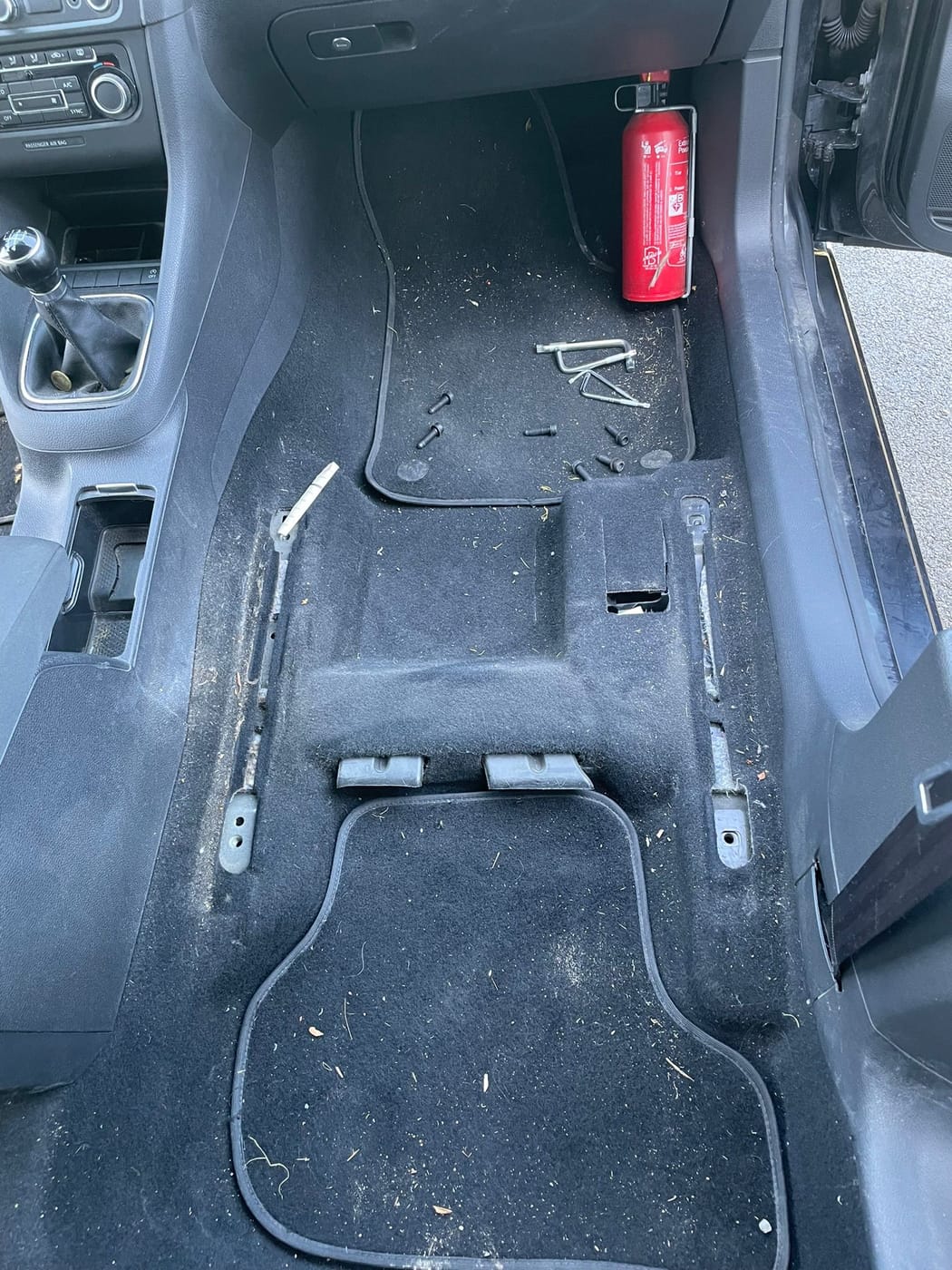 Plancher avant d'une Volkswagen Golf 6, encrassé et plein de débris, avant nettoyage